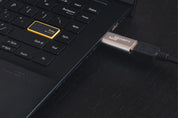 Aluminium USB Data Blocker Pro (USB-A) connected to laptop USB port – secure charge-only setup