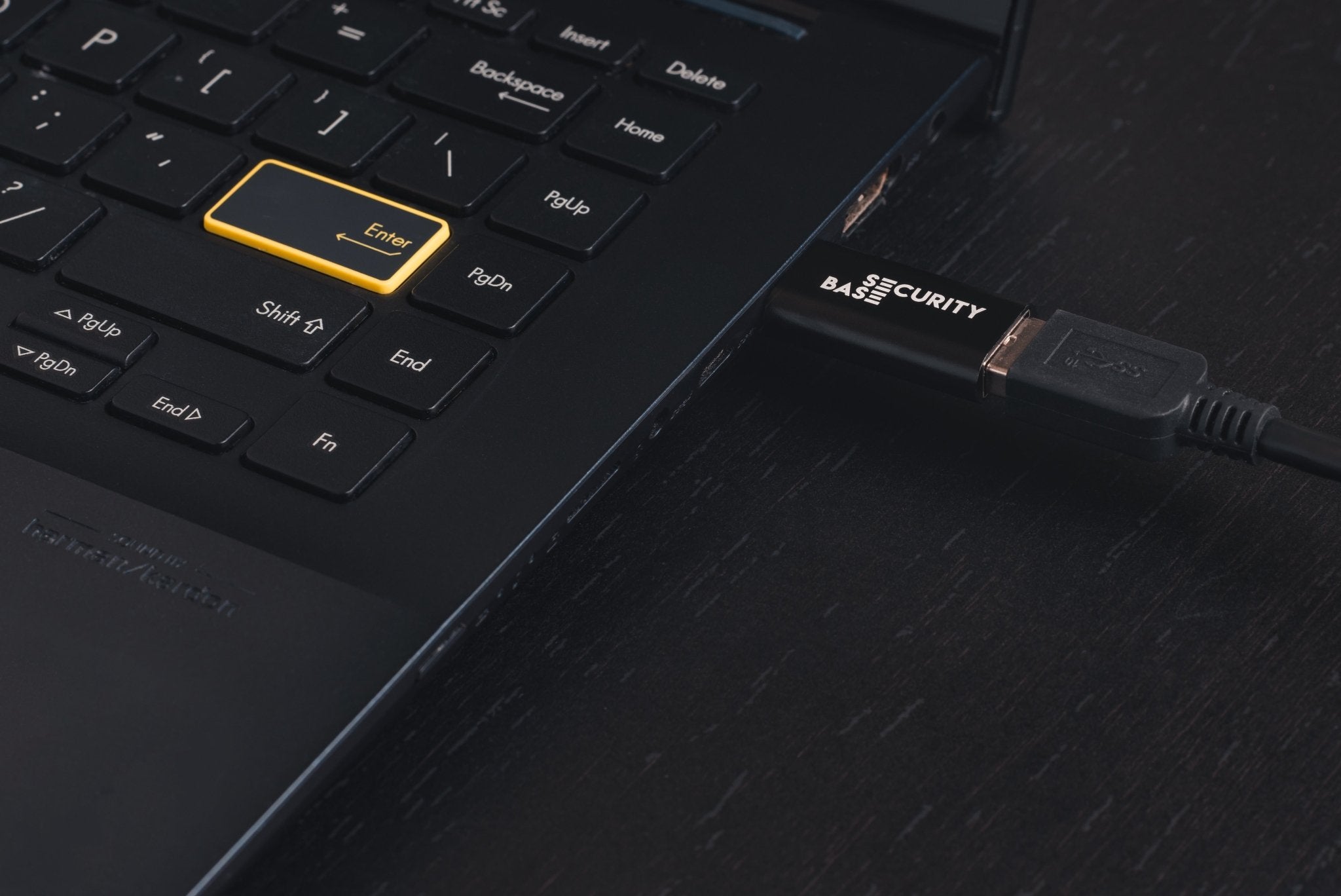 Black USB Data Blocker Pro (USB-A) connected to laptop USB port – secure charge-only setup